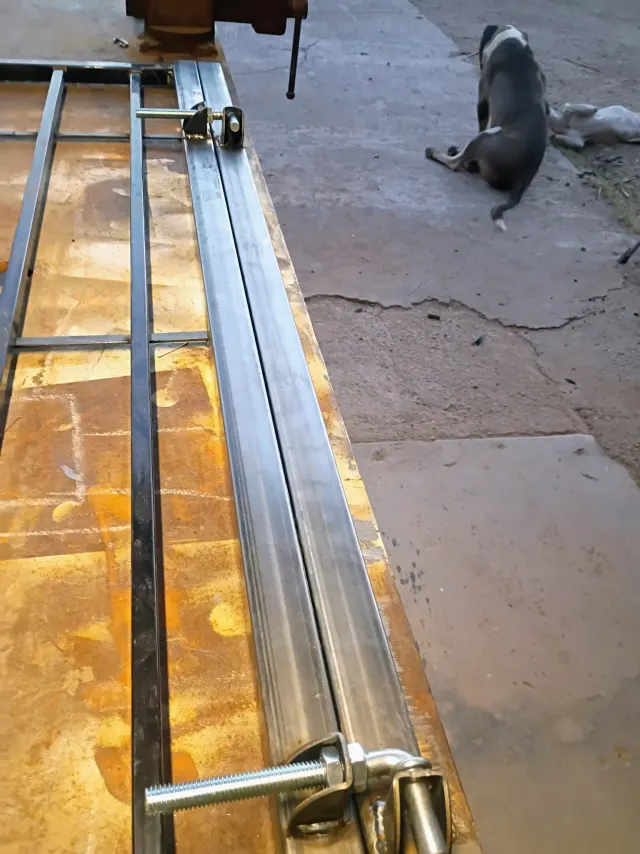 Two gate hinges lined up along a steel gate post